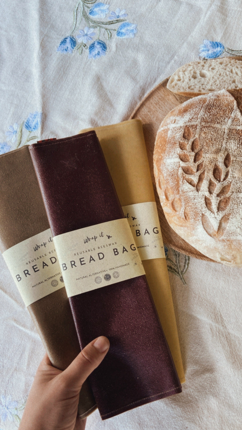 Eco-friendly reusable beeswax bread bag holding a fresh artisan sourdough loaf, made from organic cotton and natural beeswax—perfect for plastic-free, sustainable sourdough bread storage