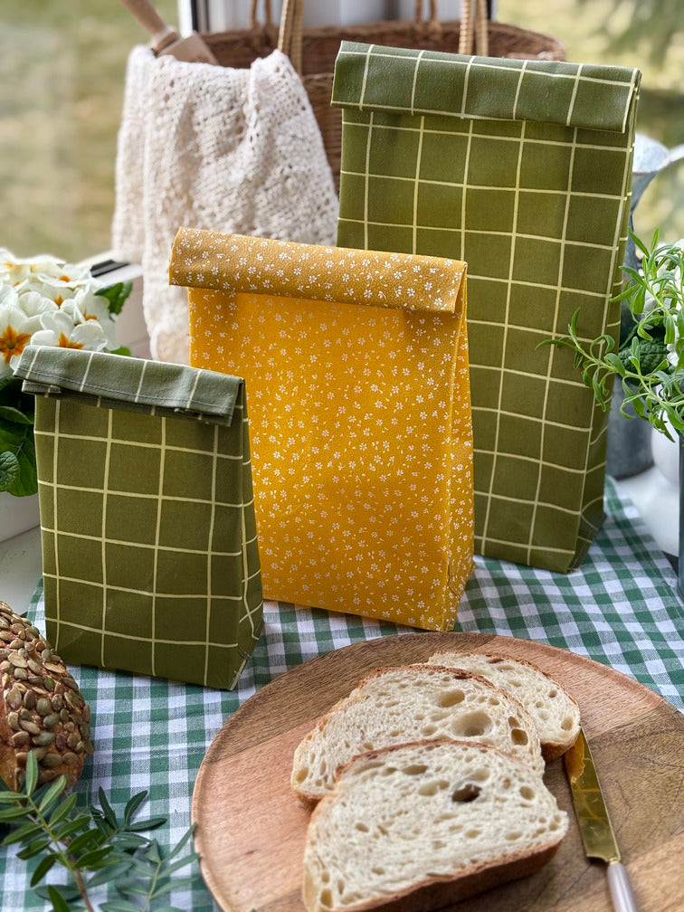 Eco-friendly reusable beeswax bread bag holding a fresh artisan sourdough loaf, made from organic cotton and natural beeswax—perfect for plastic-free, sustainable sourdough bread storage