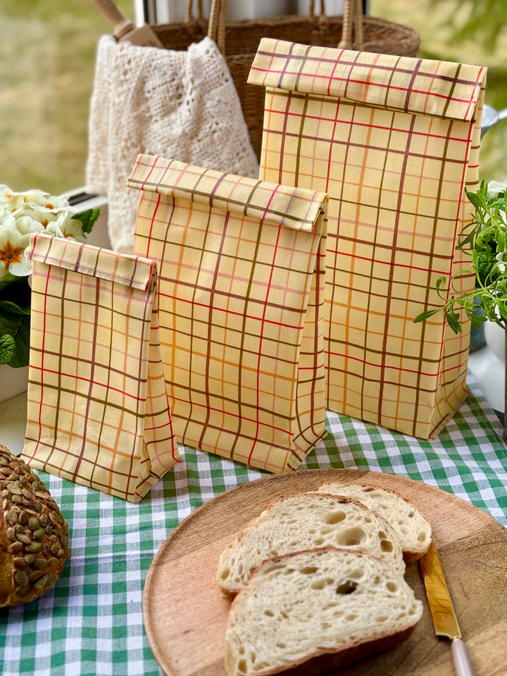 Eco-friendly reusable beeswax bread bag holding a fresh artisan sourdough loaf, made from organic cotton and natural beeswax—perfect for plastic-free, sustainable sourdough bread storage