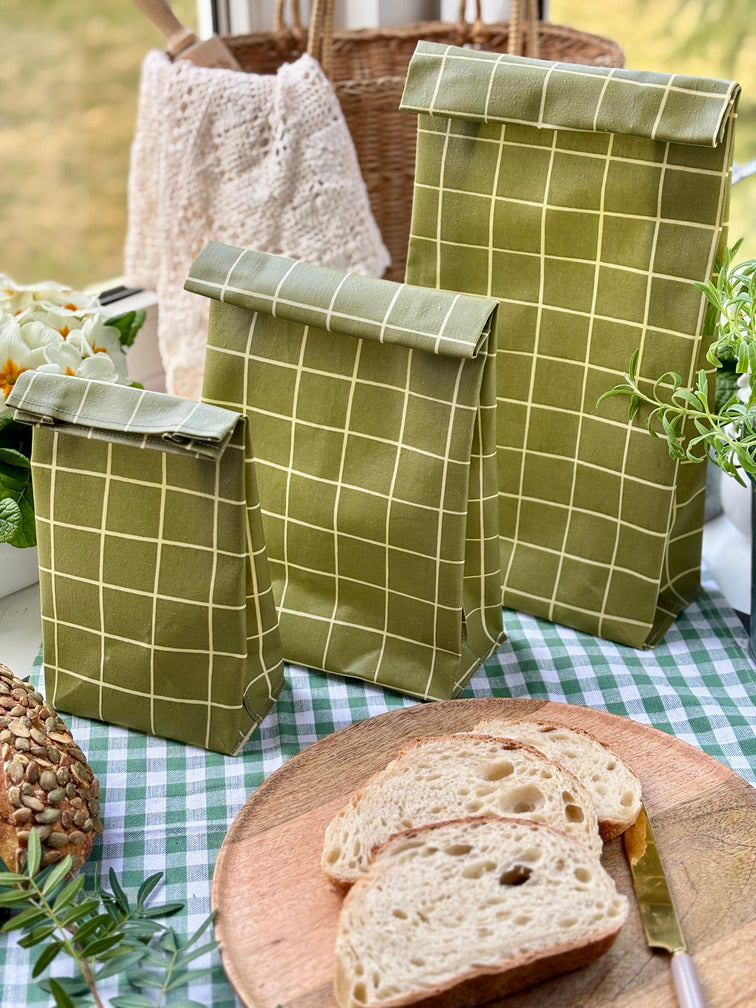 Eco-friendly reusable beeswax bread bag holding a fresh artisan sourdough loaf, made from organic cotton and natural beeswax—perfect for plastic-free, sustainable sourdough bread storage