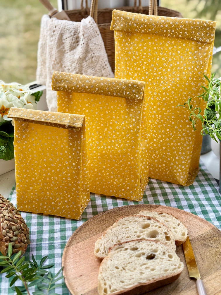 Eco-friendly reusable beeswax bread bag holding a fresh artisan sourdough loaf, made from organic cotton and natural beeswax—perfect for plastic-free, sustainable sourdough bread storage