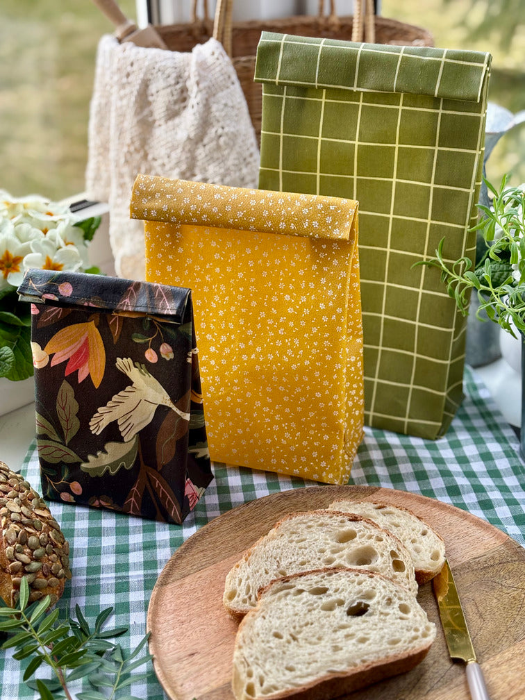 Eco-friendly reusable beeswax bread bag holding a fresh artisan sourdough loaf, made from organic cotton and natural beeswax—perfect for plastic-free, sustainable sourdough bread storage