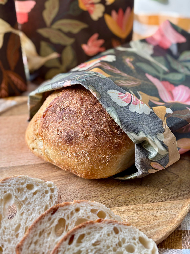 Eco-friendly reusable beeswax bread bag holding a fresh artisan sourdough loaf, made from organic cotton and natural beeswax—perfect for plastic-free, sustainable sourdough bread storage