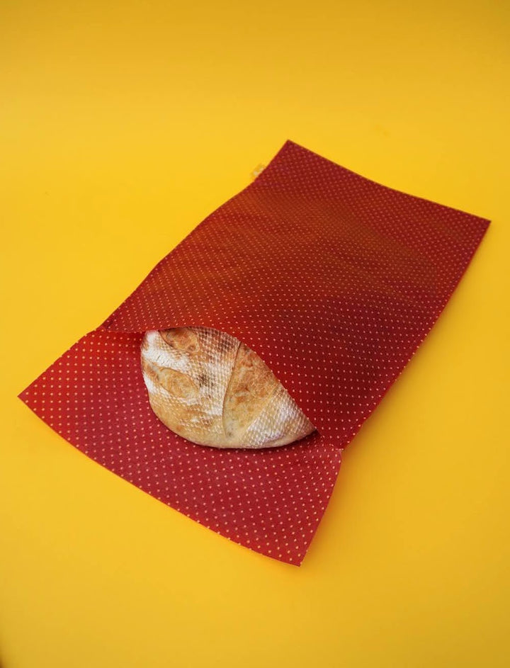 Eco-friendly reusable beeswax bread bag holding a fresh artisan sourdough loaf, made from organic cotton and natural beeswax—perfect for plastic-free, sustainable sourdough bread storage